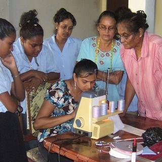 Nanaimo Sewing School Students, under the watchful eyes of Mrs. Habbibullah, right, using the "serger" sewing machine for the first time. 