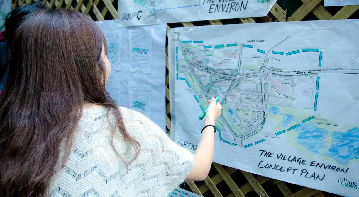 Master of Community Planning students discussing a village concept plan