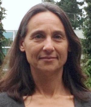 Woman with long brown hair wearing a grey top